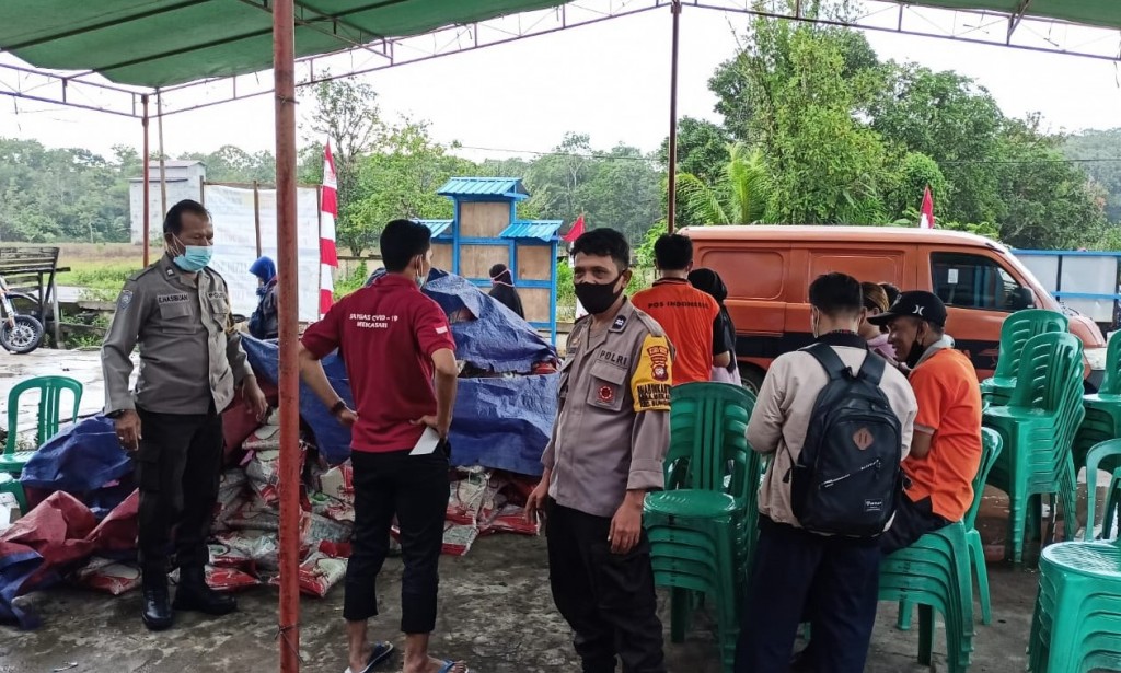 Dua Bhabinkamtibmas Polsek Sungai Raya Amankan Pembagian BPNT dan PKH.